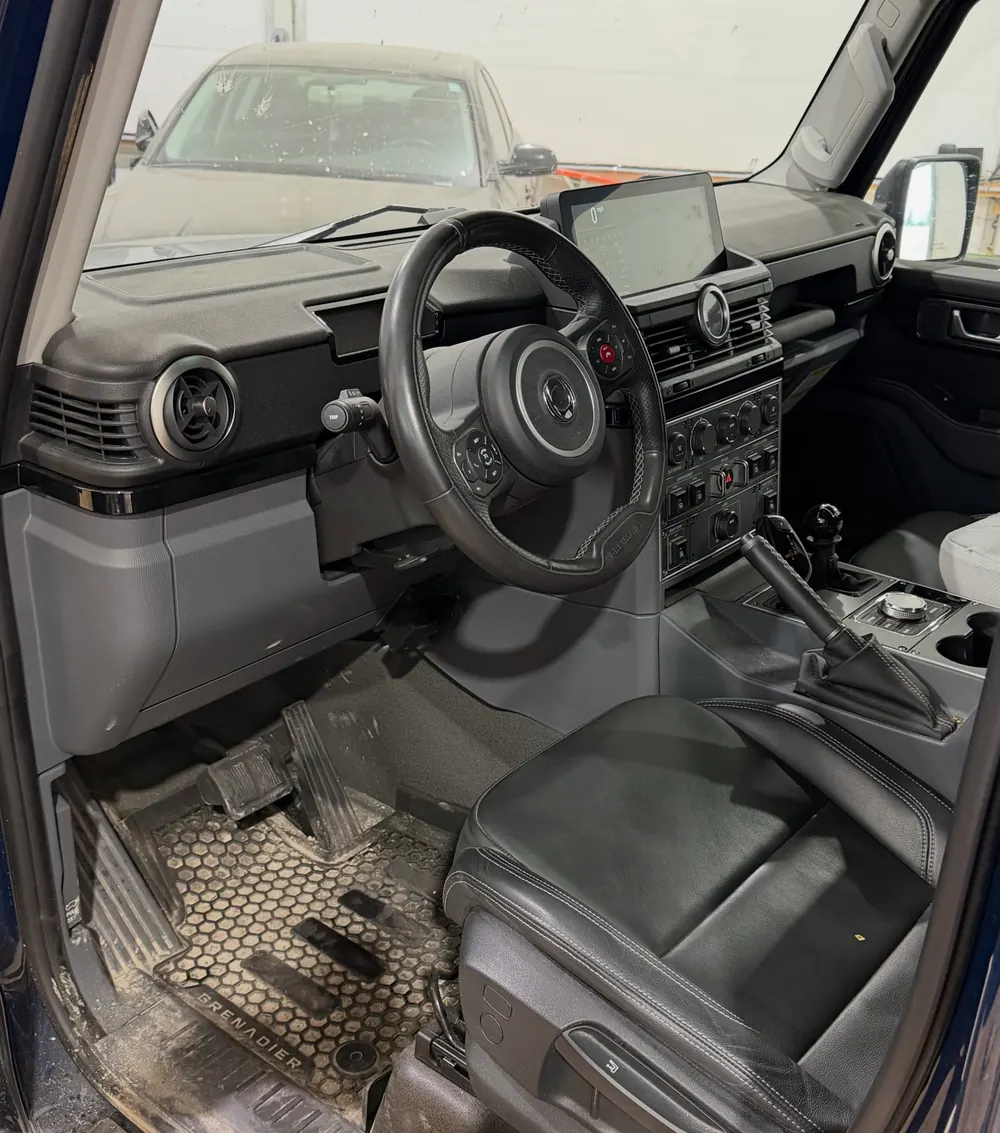 Ineos Grenadier interior with black leather seats and rubber floor mats after a full detail